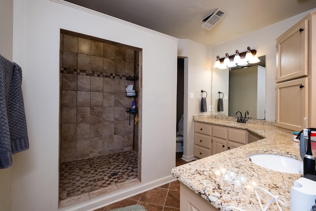 bathroom with tile patterned floors, visible vents, vanity, baseboards, and tiled shower