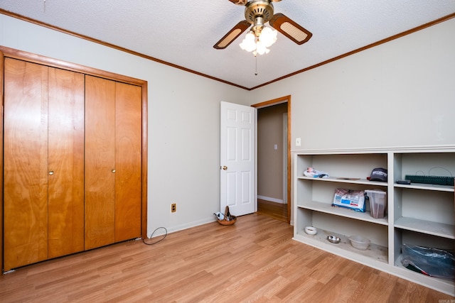 unfurnished bedroom featuring light wood-style flooring, a textured ceiling, baseboards, a closet, and ornamental molding