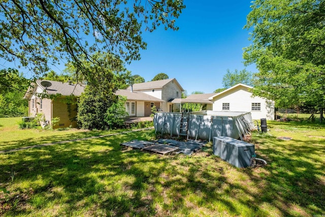rear view of property with fence and a lawn