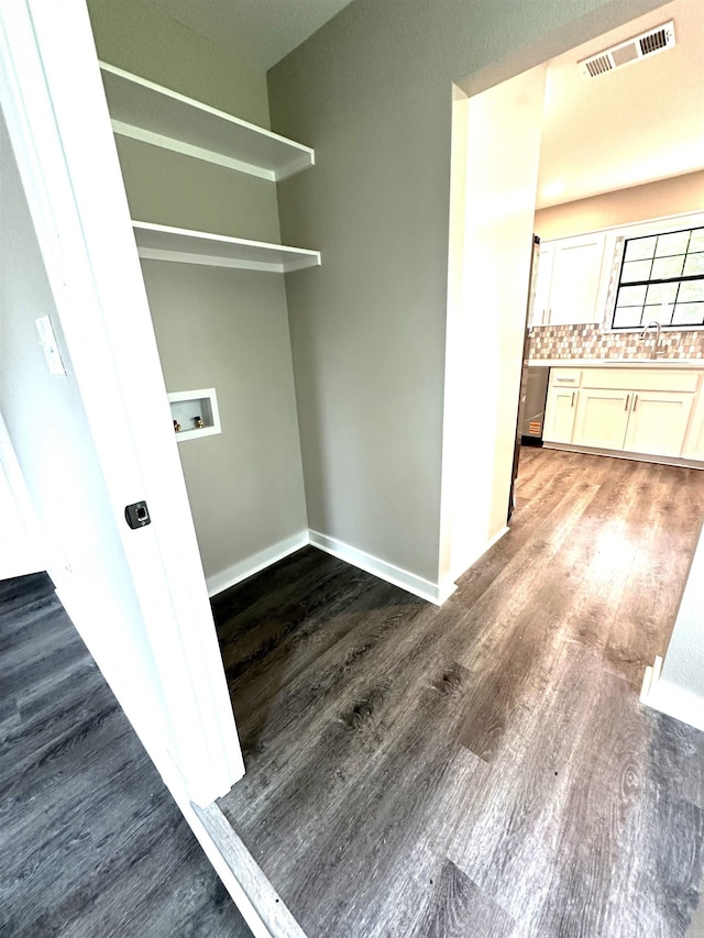 washroom featuring wood finished floors, washer hookup, and baseboards