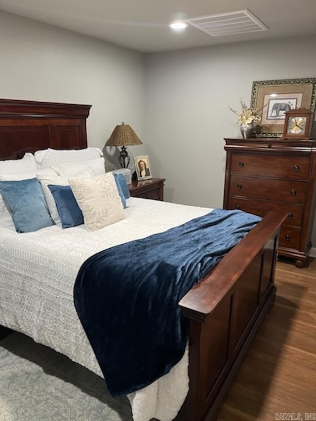 bedroom with wood finished floors, visible vents, and recessed lighting