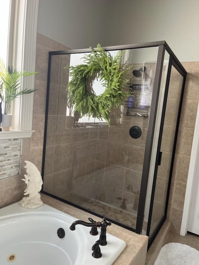 bathroom featuring a shower stall, a bath, and a sink