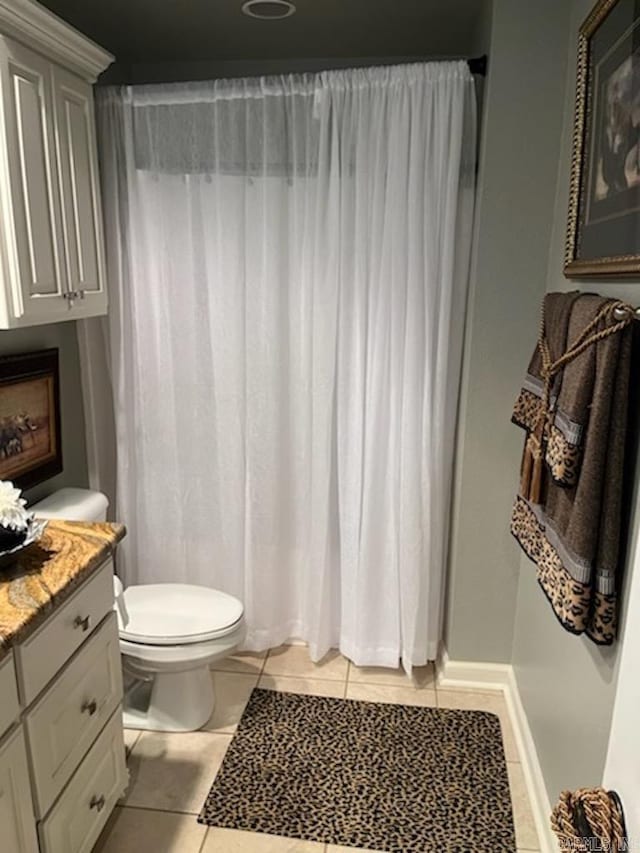 full bath featuring curtained shower, tile patterned floors, vanity, and toilet