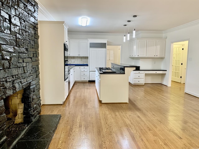 kitchen featuring black stovetop, dark countertops, a kitchen island, crown molding, and pendant lighting