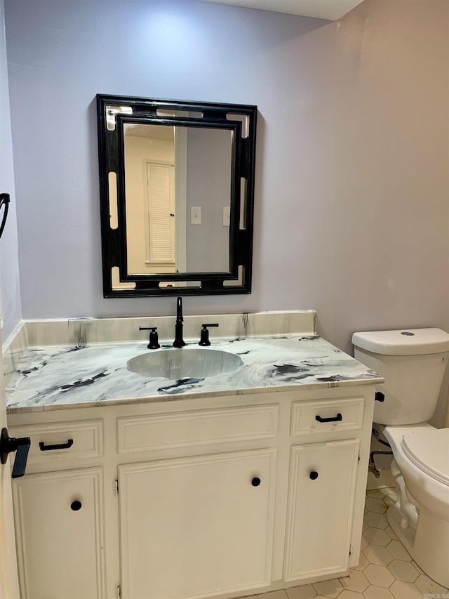 bathroom featuring tile patterned floors, vanity, and toilet