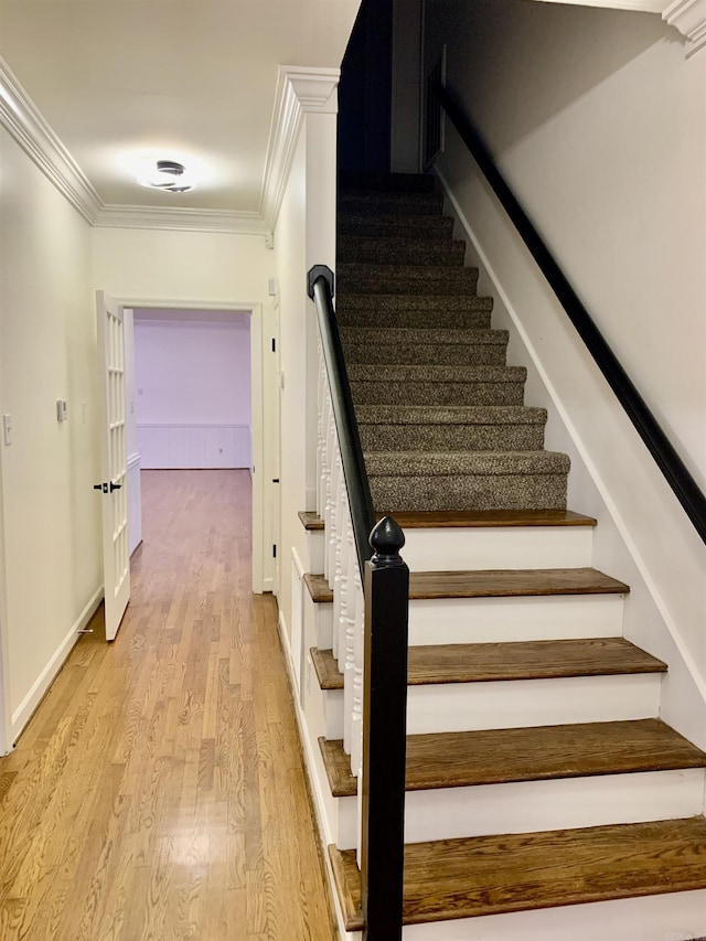stairs featuring baseboards, crown molding, and wood finished floors