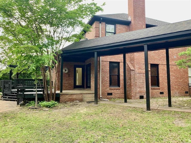 view of home's exterior featuring crawl space, a lawn, a chimney, a shingled roof, and brick siding