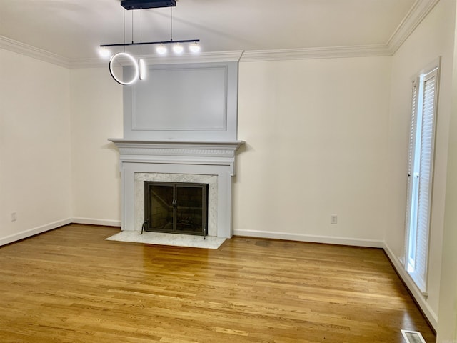 unfurnished living room with light wood finished floors, visible vents, crown molding, and baseboards