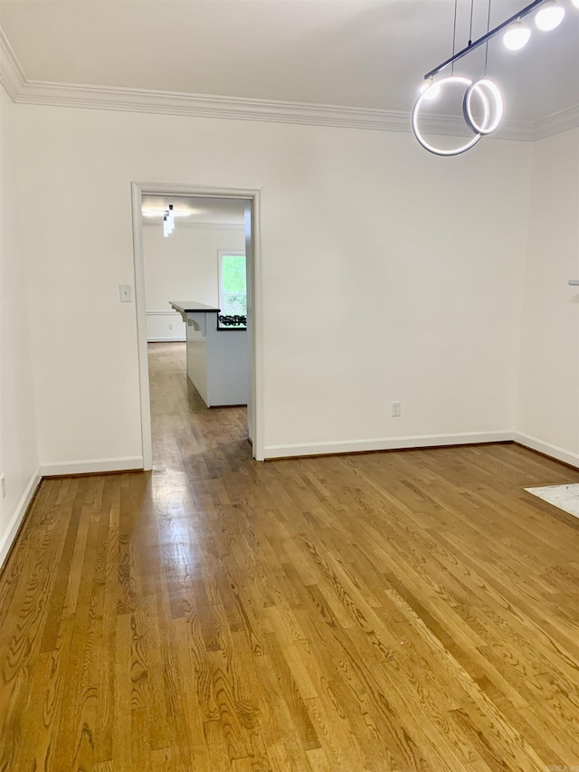 interior space featuring baseboards, wood finished floors, and ornamental molding