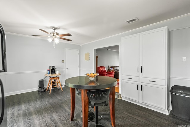 dining area with crown molding, a ceiling fan, visible vents, and dark wood-type flooring