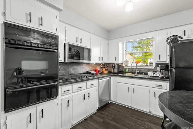 kitchen featuring a warming drawer, black appliances, a sink, and dark countertops