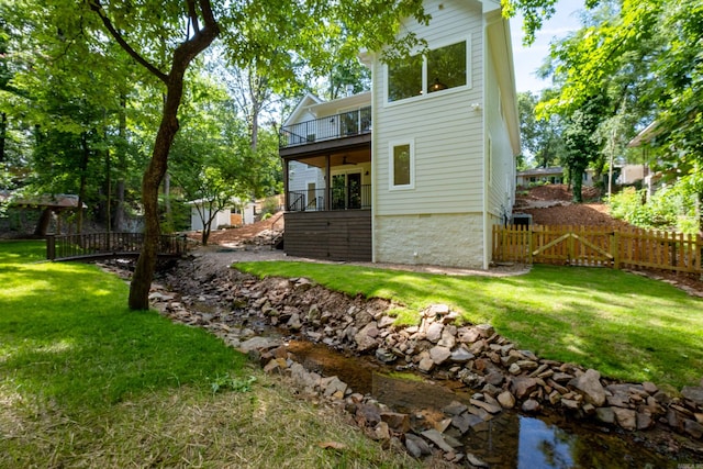 6600 Waverly Dr, Little Rock, AR 72207 - rear view of house featuring a lawn, fence, a ceiling fan, and a balcony