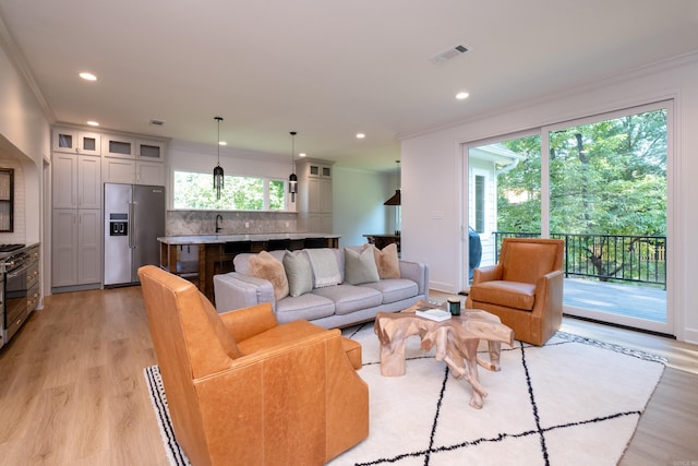 6600 Waverly Dr, Little Rock, AR 72207 - living area with light wood-type flooring, visible vents, a wealth of natural light, and ornamental molding