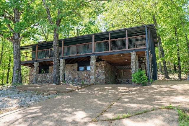 view of front of home with a wooden deck and stone siding