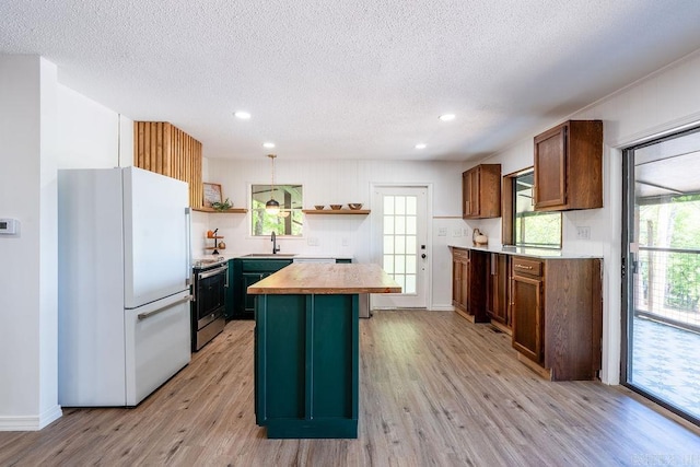 kitchen featuring open shelves, a sink, freestanding refrigerator, stainless steel electric stove, and a textured ceiling