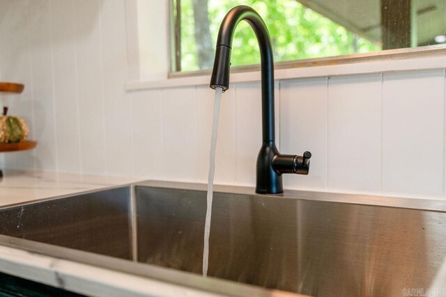 interior details with a sink and white cabinetry