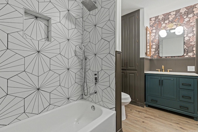 full bath with toilet, vanity, wood finished floors, and shower / tub combination
