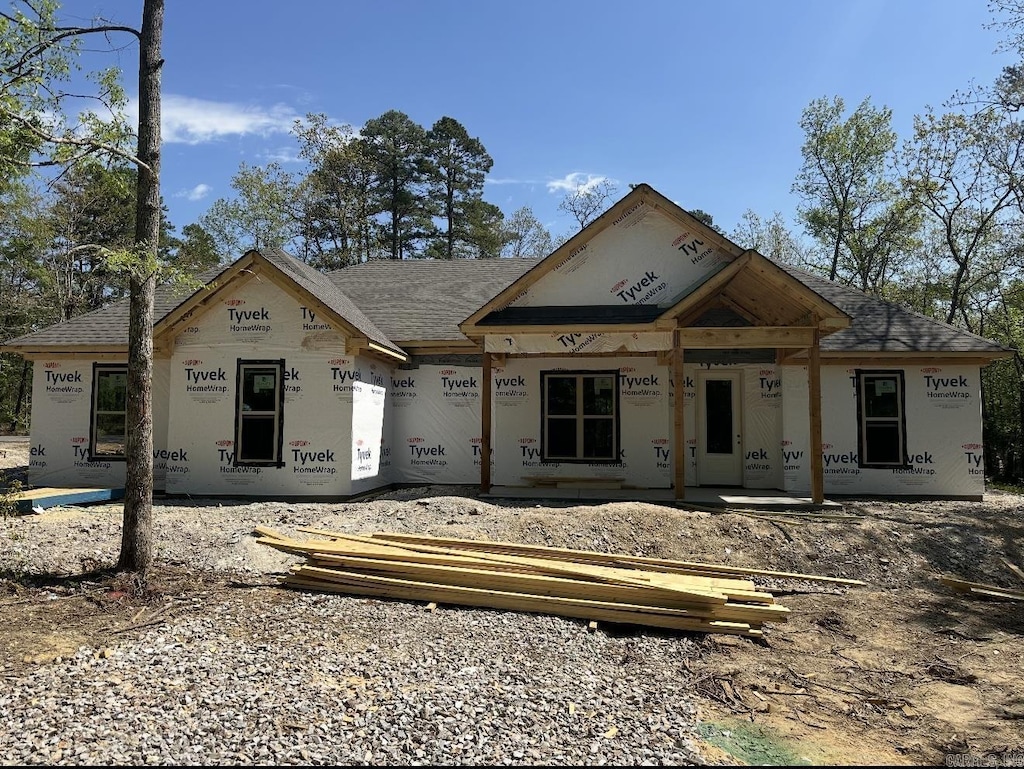 property under construction with a porch and a shingled roof