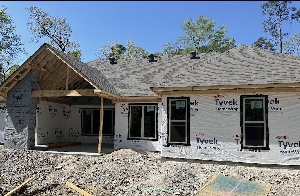 rear view of property with a shingled roof
