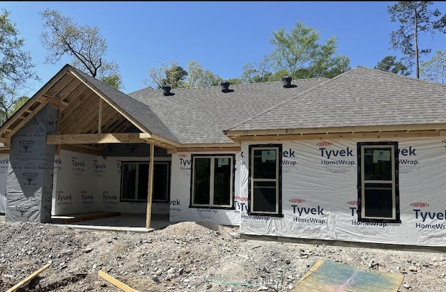rear view of property with a shingled roof
