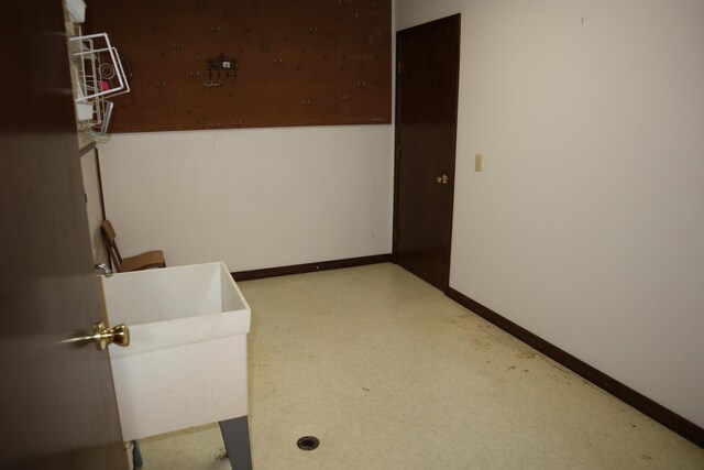 empty room with baseboards and a sink