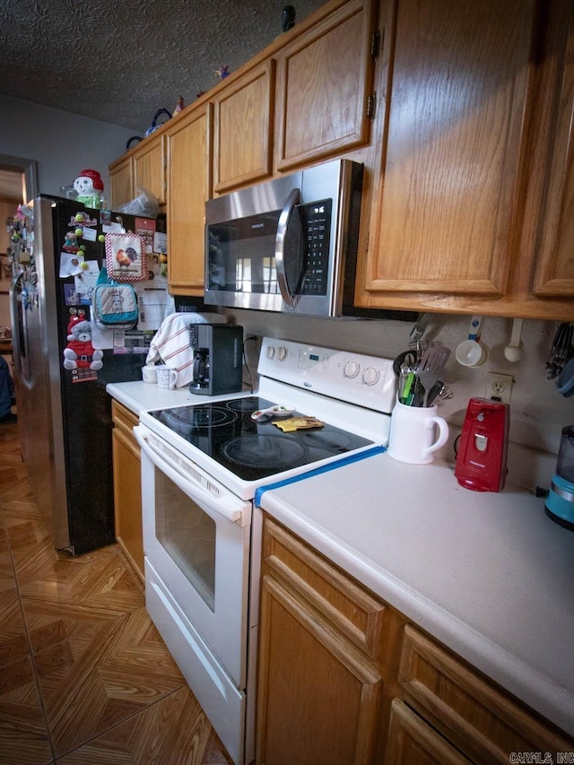 kitchen with light countertops, brown cabinetry, and stainless steel appliances