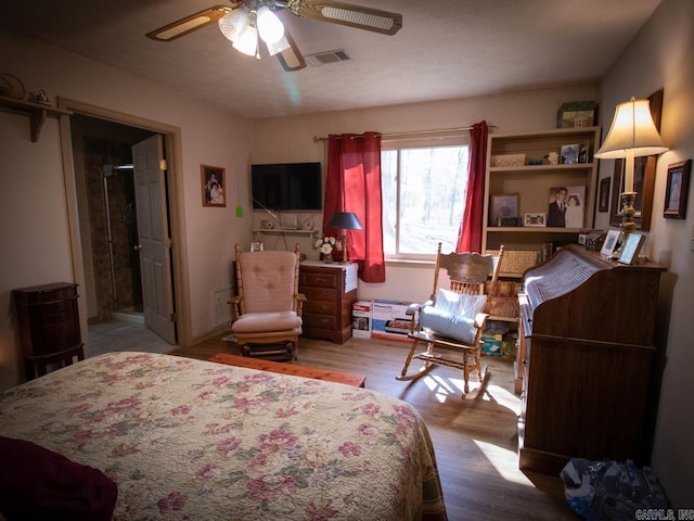 bedroom with visible vents, wood finished floors, and ceiling fan