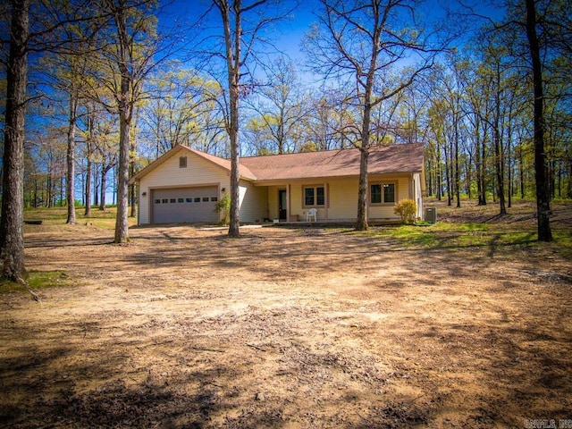 view of front of property featuring driveway, covered porch, and a garage