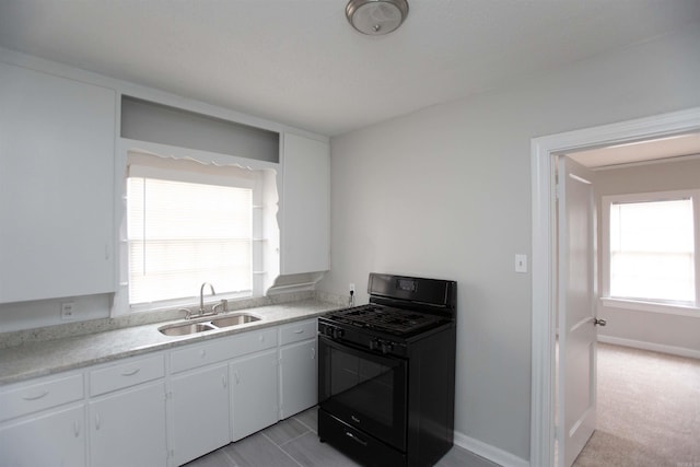 2713 S Van Buren St, Little Rock, AR 72204 - kitchen with a sink, baseboards, white cabinetry, gas stove, and light countertops