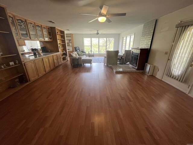living room with visible vents, a ceiling fan, dark wood-style floors, and a fireplace