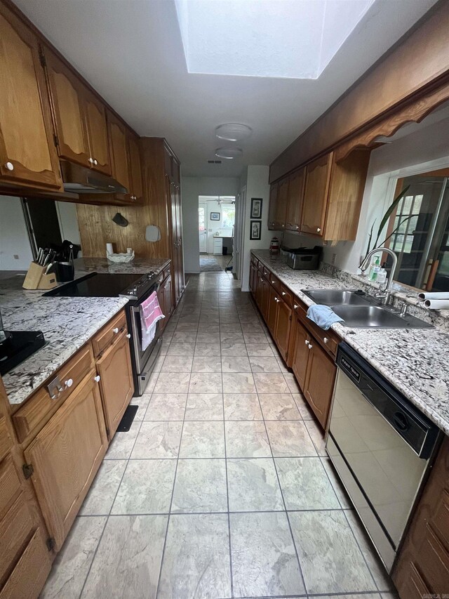kitchen featuring a sink, light stone countertops, dishwasher, under cabinet range hood, and electric stove