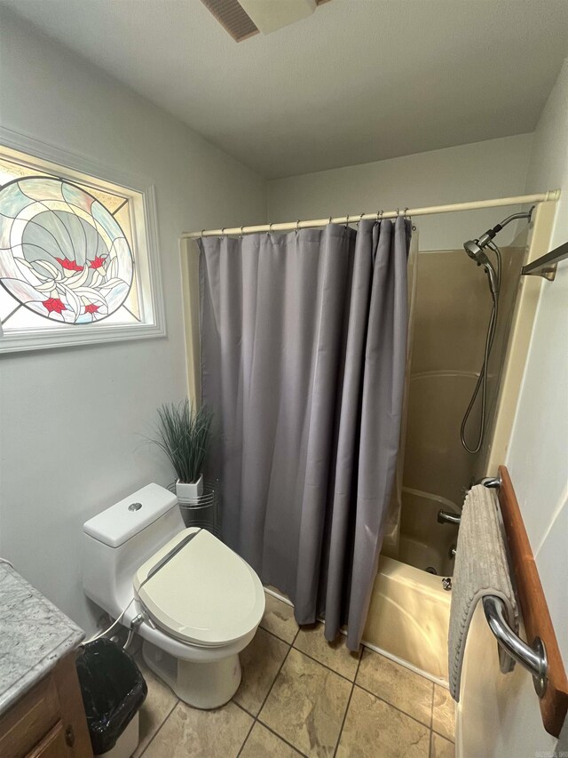 bathroom featuring shower / bath combination with curtain, vanity, tile patterned flooring, and toilet