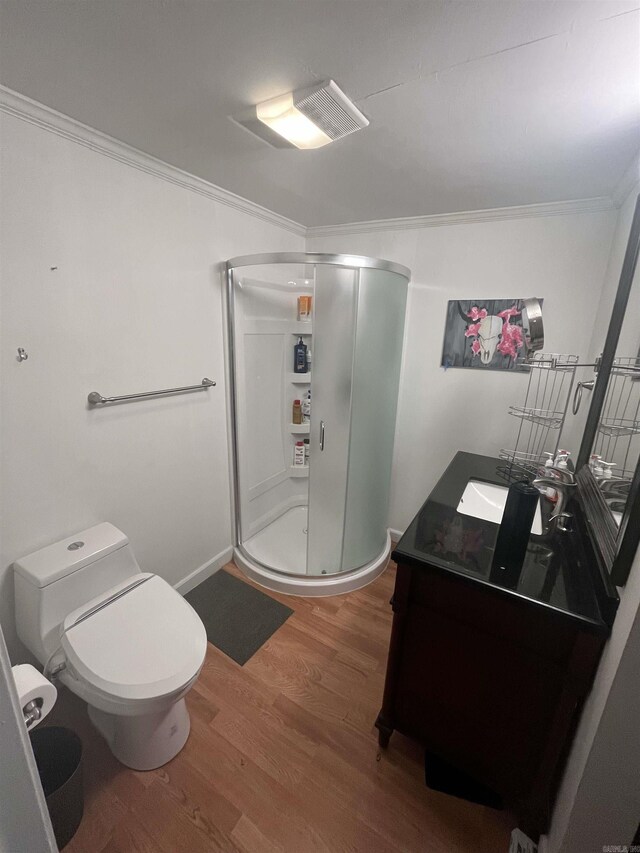 bathroom featuring vanity, wood finished floors, a shower stall, and ornamental molding