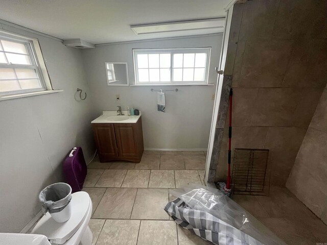 full bathroom with a tile shower, a wealth of natural light, tile patterned flooring, and vanity