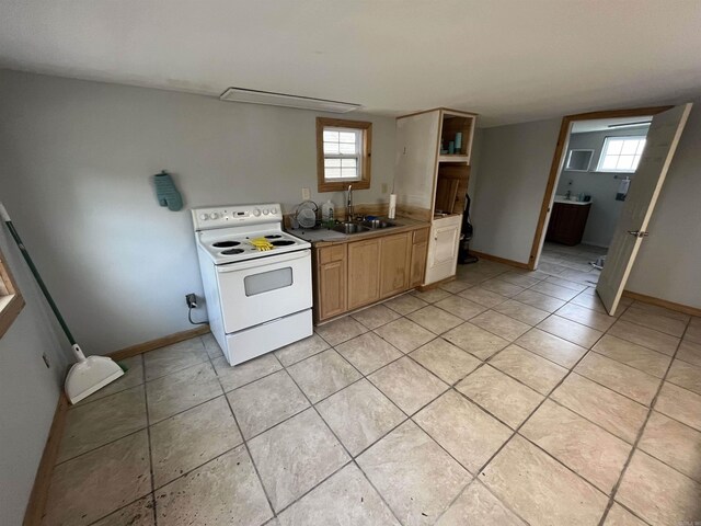 kitchen featuring white range with electric cooktop, baseboards, light tile patterned floors, and a sink