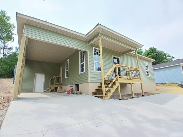 rear view of house with concrete driveway and a carport