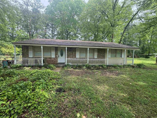 ranch-style home featuring brick siding and covered porch