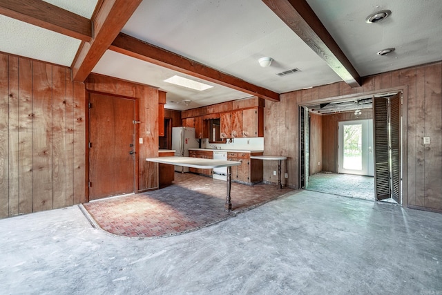106 Nottingham Way, Prescott, AR 71857 - kitchen with visible vents, beamed ceiling, wood walls, white appliances, and light countertops