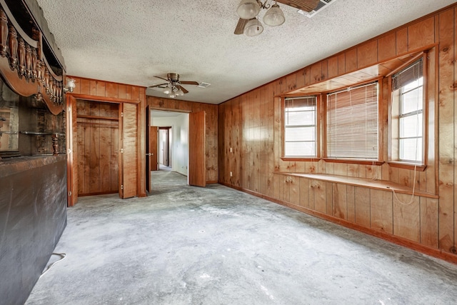 106 Nottingham Way, Prescott, AR 71857 - spare room with unfinished concrete floors, a ceiling fan, a textured ceiling, and wooden walls
