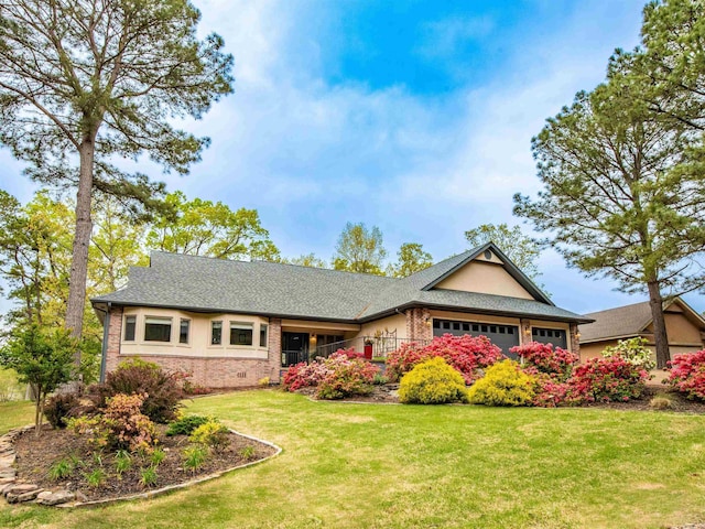 ranch-style home with an attached garage, a shingled roof, a front lawn, and brick siding