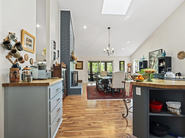 kitchen with open shelves, high vaulted ceiling, butcher block countertops, and light wood finished floors
