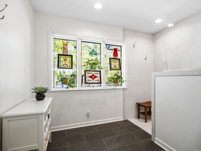 interior space featuring recessed lighting, dark tile patterned floors, and baseboards