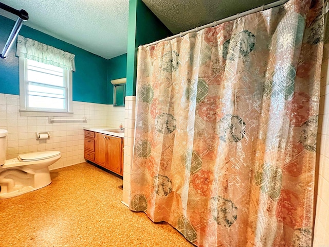 40 Sutton Ln, Batesville, AR 72501 - bathroom featuring a wainscoted wall, toilet, vanity, tile walls, and a textured ceiling