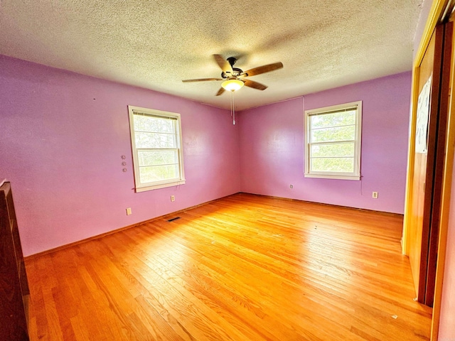 40 Sutton Ln, Batesville, AR 72501 - empty room featuring light wood-style flooring, a textured ceiling, and a healthy amount of sunlight