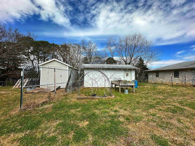 40 Sutton Ln, Batesville, AR 72501 - rear view of property with an outdoor structure, fence, a yard, and a vegetable garden