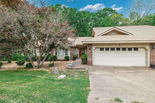 single story home with concrete driveway, a front lawn, a garage, brick siding, and roof with shingles