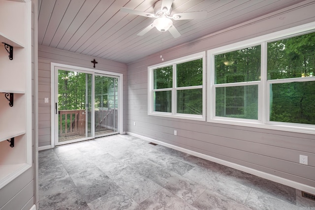 unfurnished sunroom with ceiling fan, visible vents, and plenty of natural light