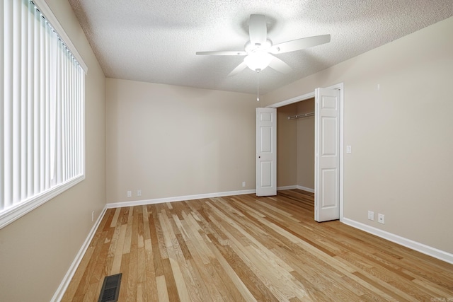 unfurnished bedroom with baseboards, a textured ceiling, visible vents, and light wood-style flooring