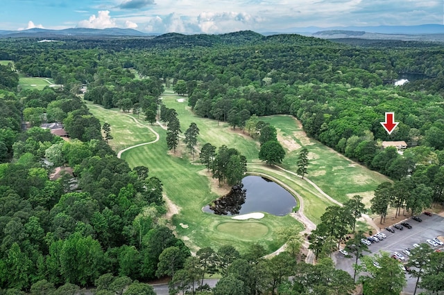 birds eye view of property with a water and mountain view, a forest view, and view of golf course