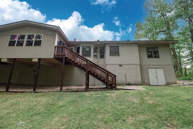 rear view of property featuring a wooden deck, a yard, and stairway